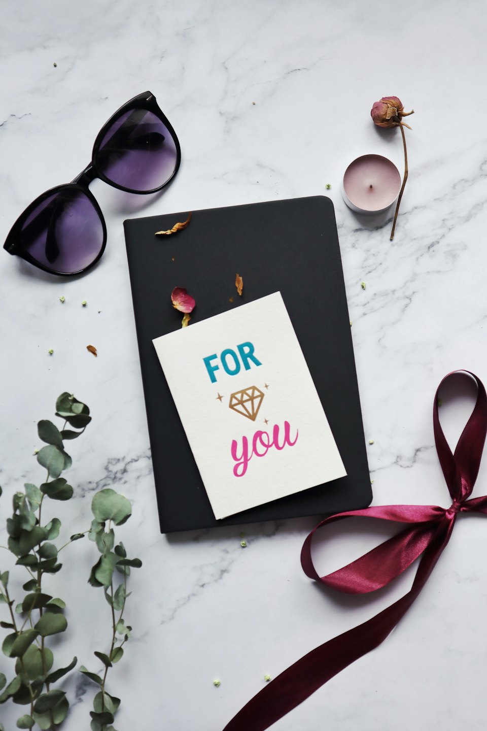 Gift items and a handwritten note arranged on marble.